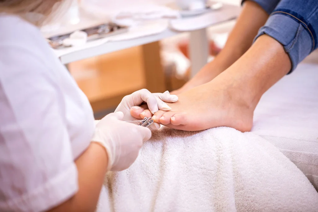 A beautician clipping off the nail - Pedicure service