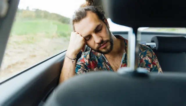 A man taking a nap in the car